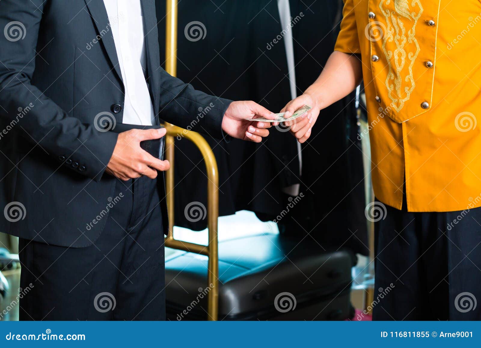 midsection view of man giving tip in hotel