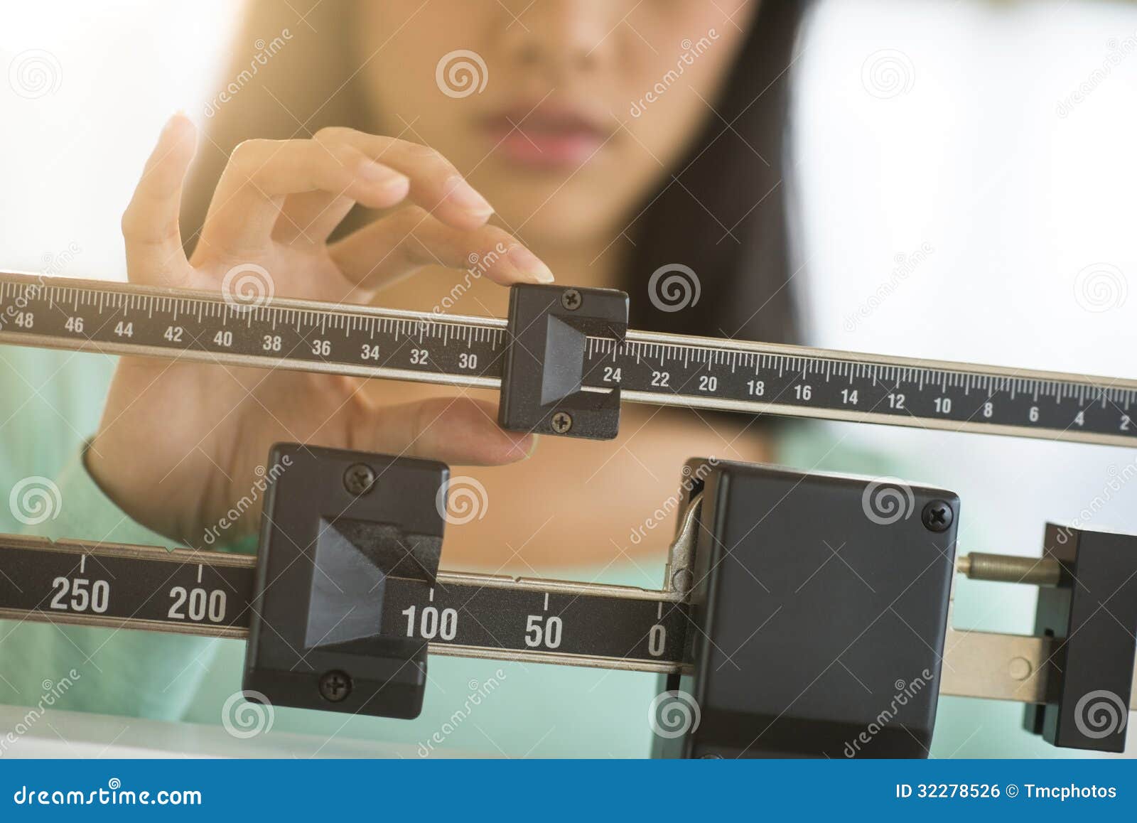 midsection of woman adjusting weight scale