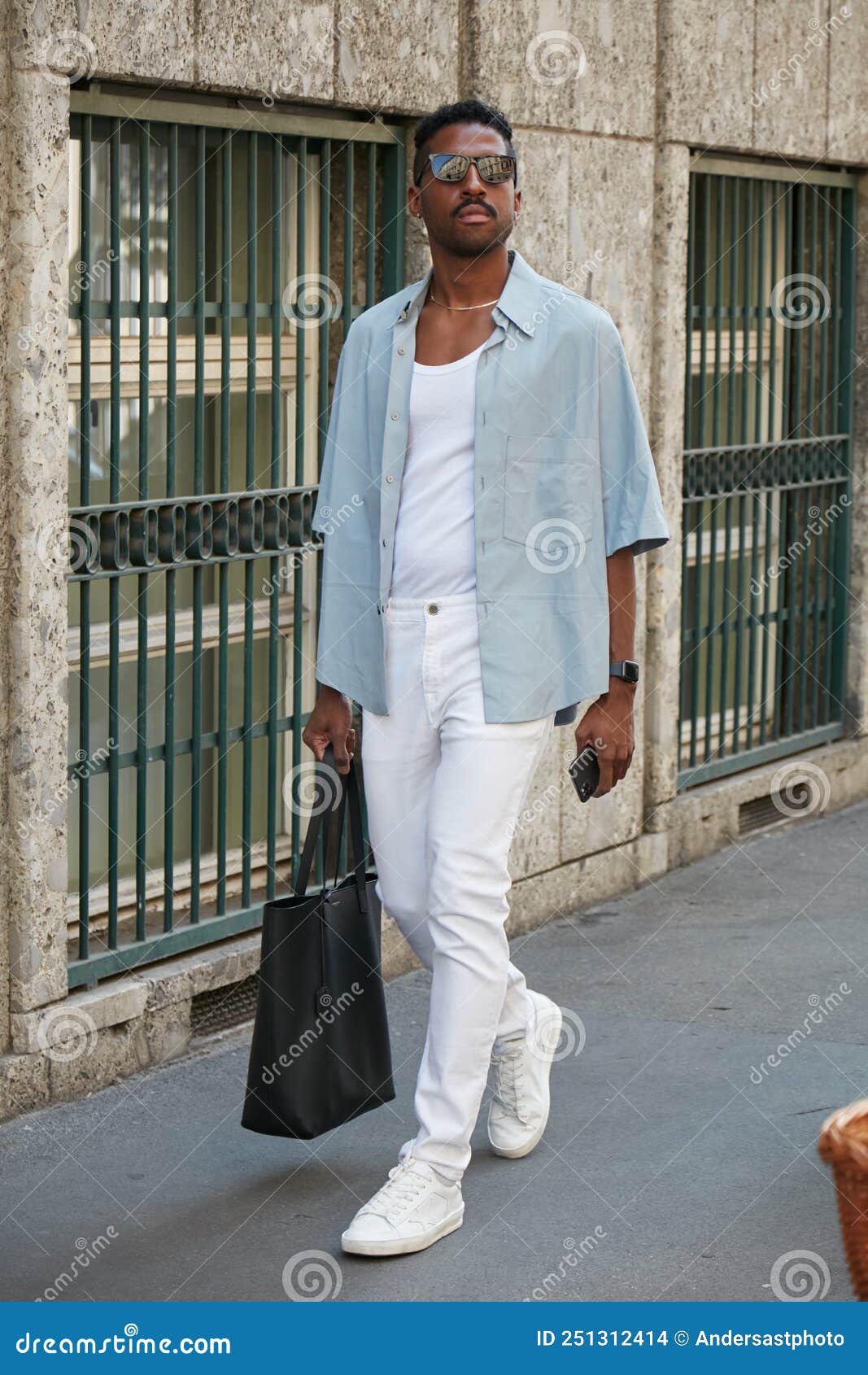 Man with Pale Blue Shirt, White Trousers and Sneakers before