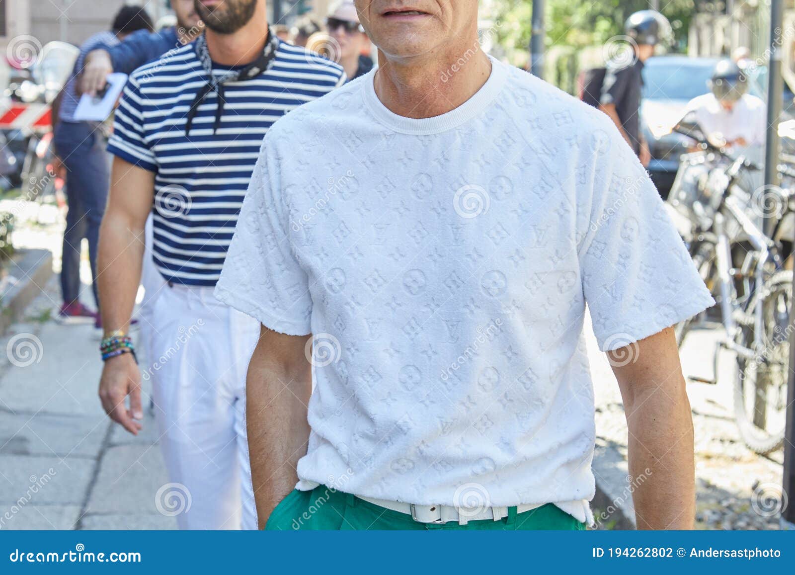 Man with White Louis Vuitton Shirt and Green Trousers before Les