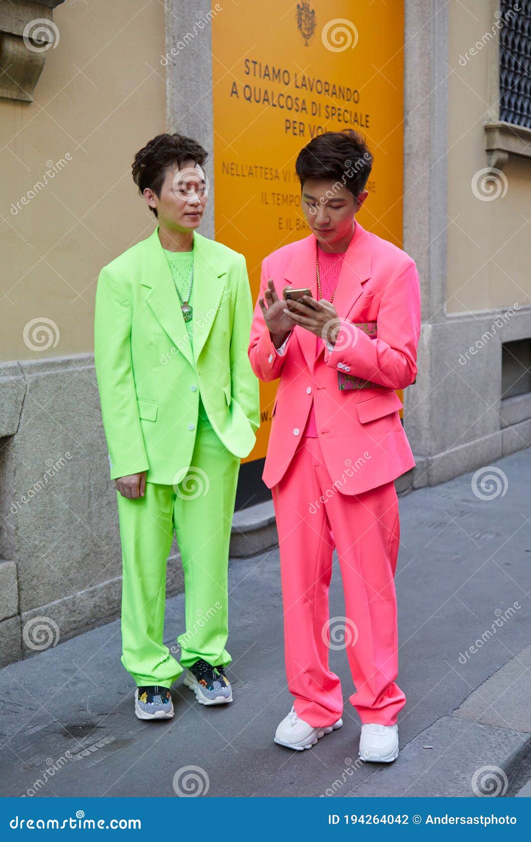 Men with Green and Pink Suit Looking at Smartphone before Versace ...