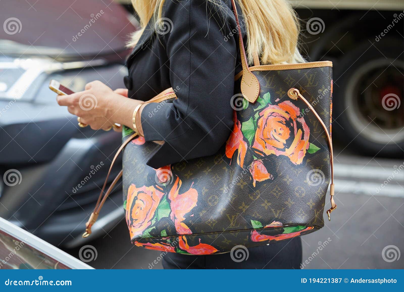 MILAN - SEPTEMBER 23: Woman with black Louis Vuitton bag with pink