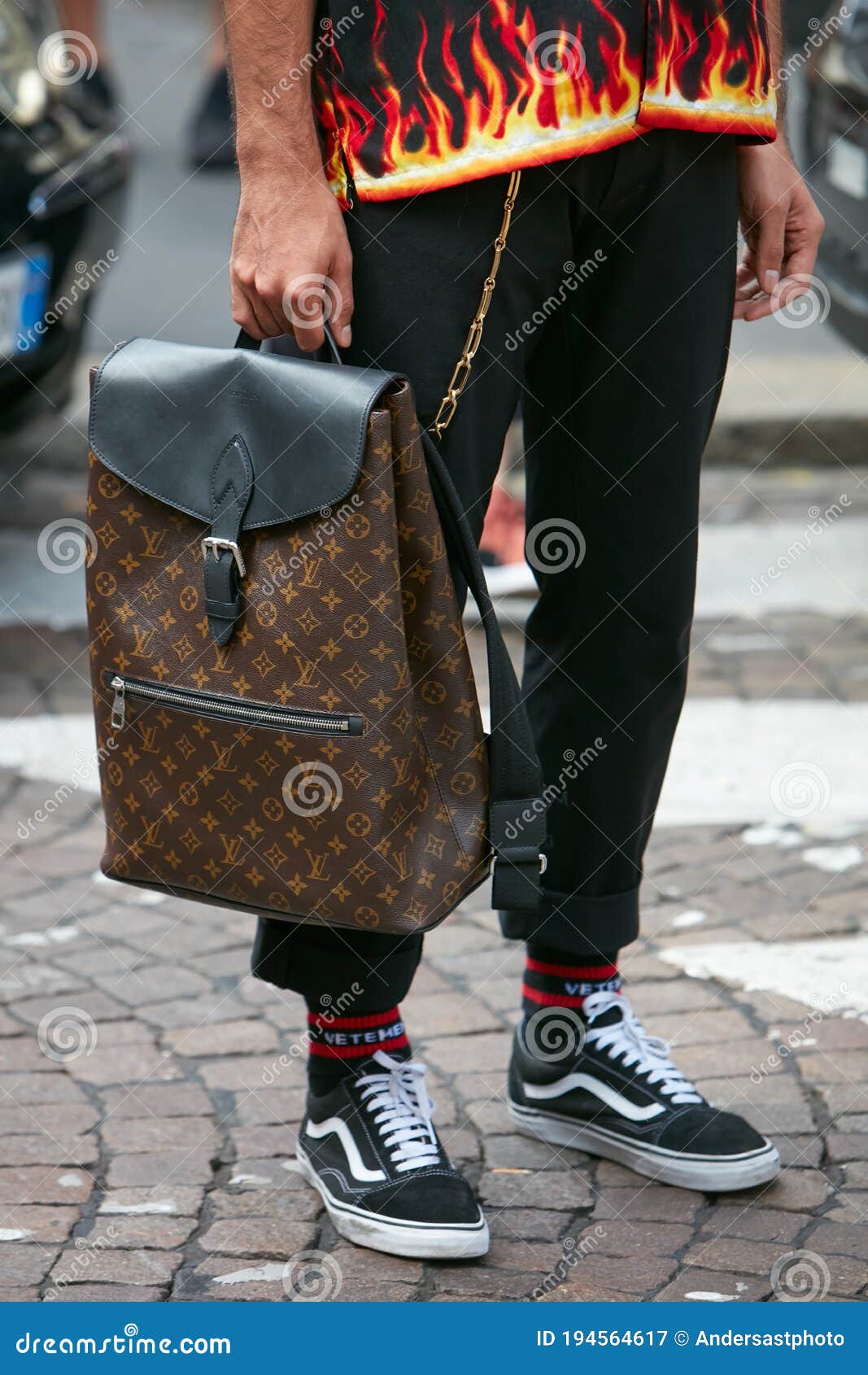 Man with Louis Vuitton Backpack and Shirt with Flames before