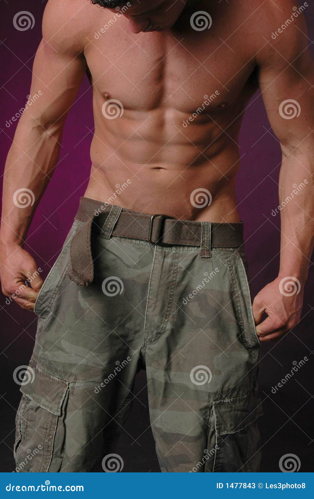 Hombre con pantalones militares con el torso desnudo. disparo vertical
