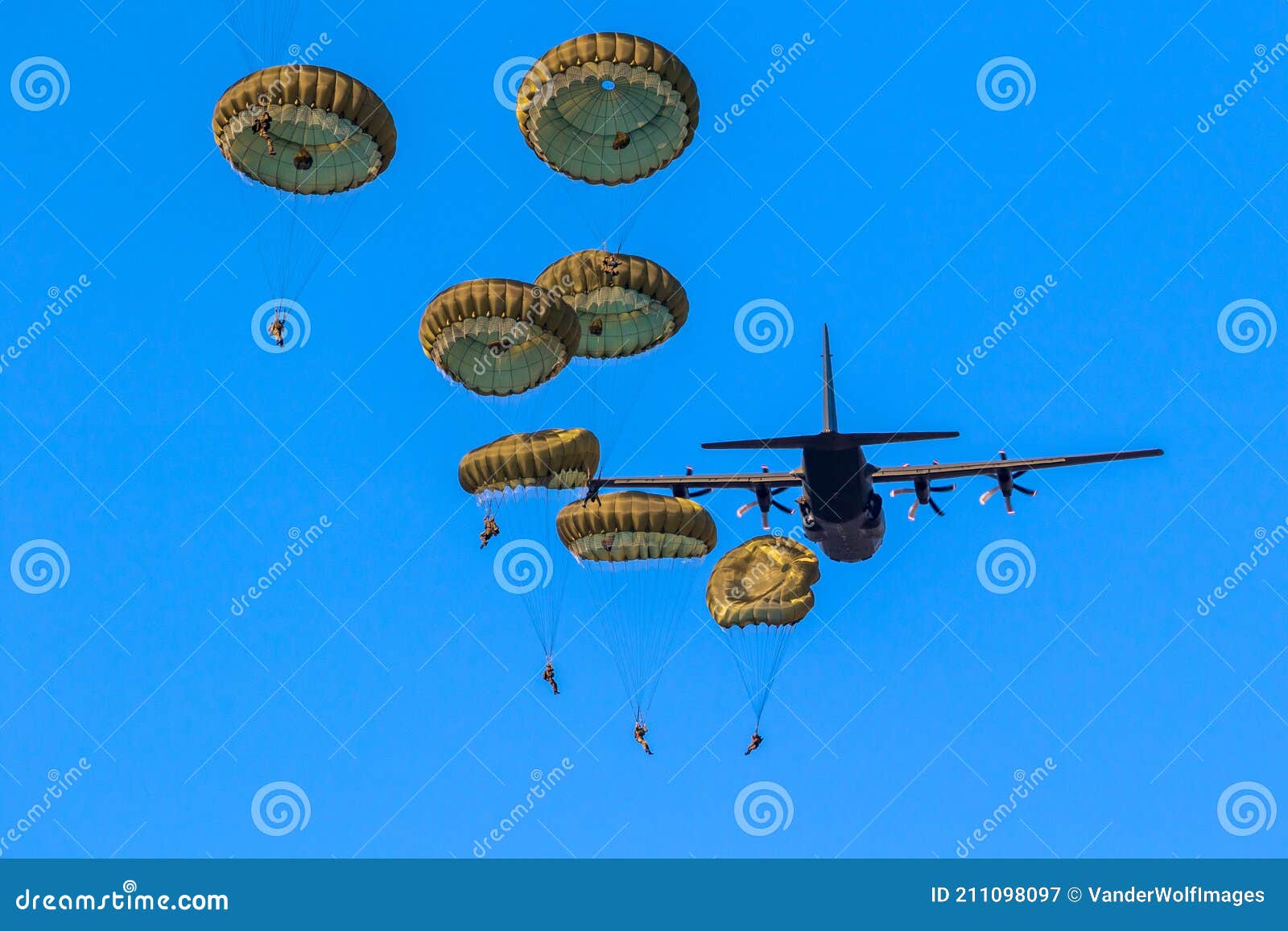 military parachutist paratroopers parachute jumping out of a air force planes on a clear blue sky day