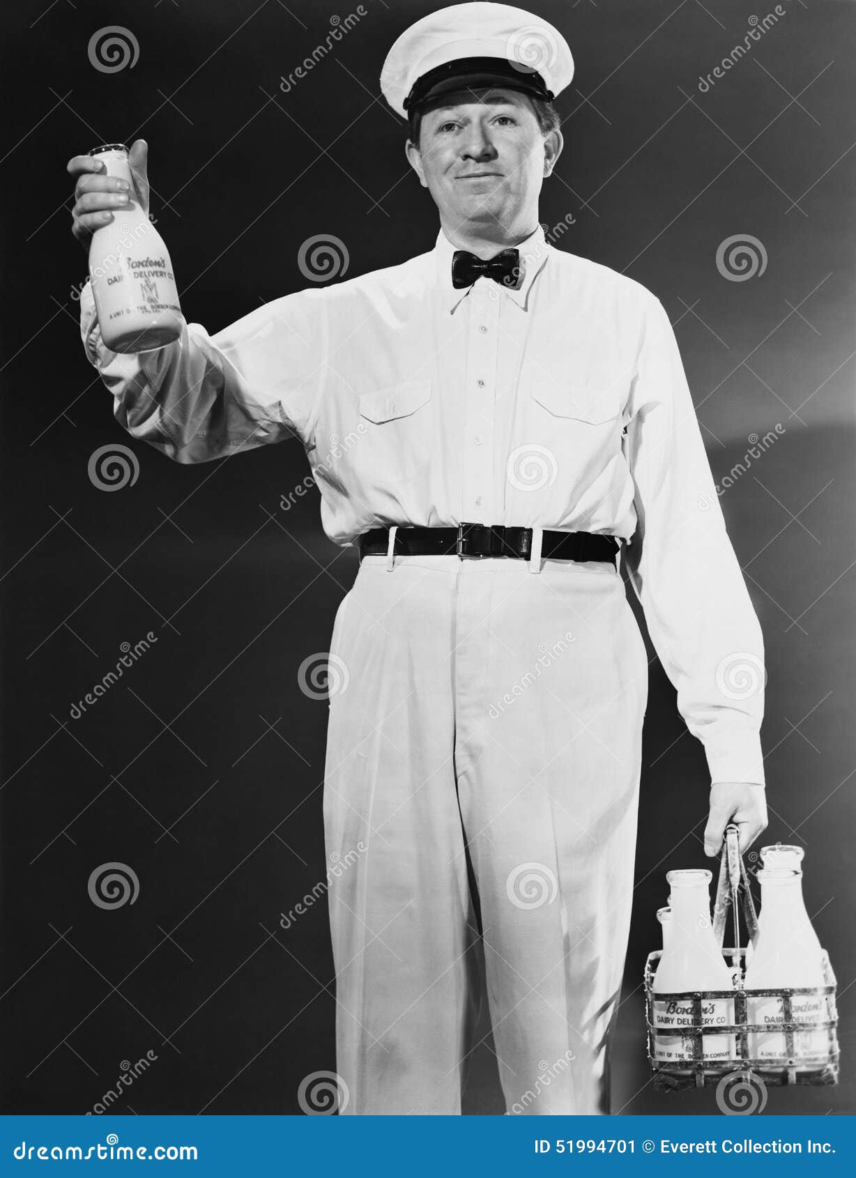 1940s 1950s SMILING HOME DELIVERY MILKMAN STANDING NEXT TO BOTTLES OF