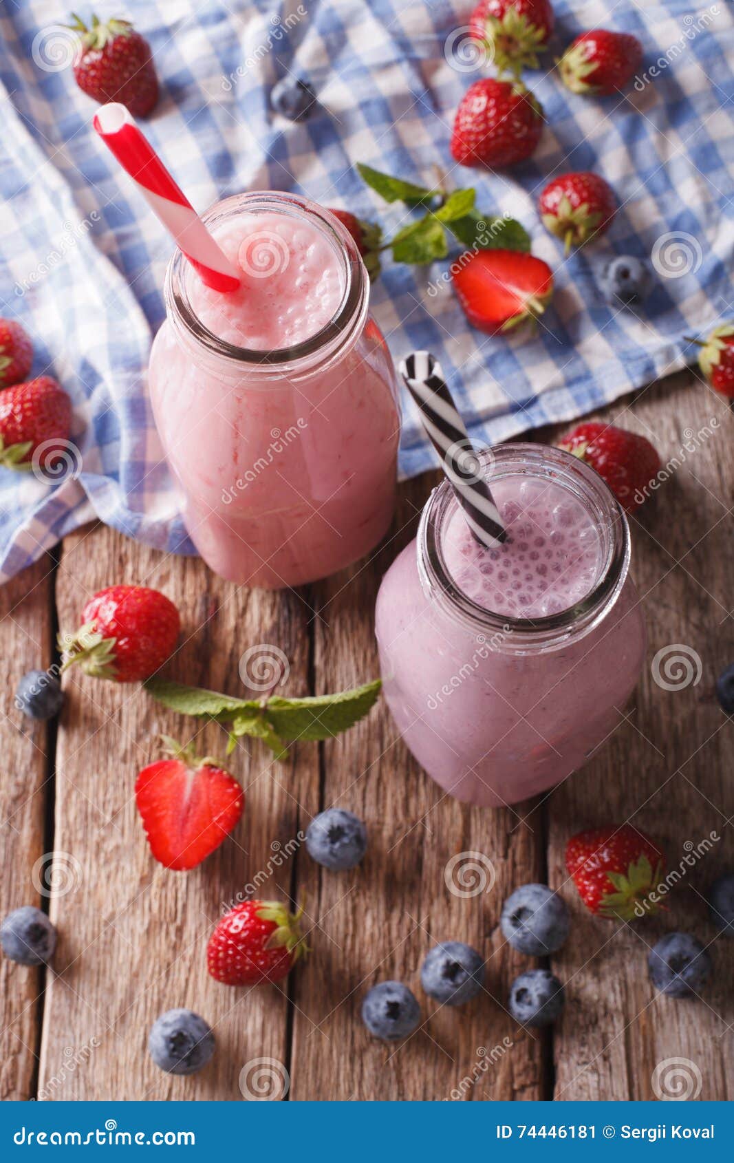 Milkshakes with Strawberries and Blueberries in Bottles Closeup
