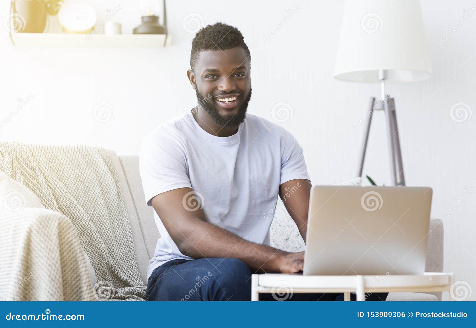 millennial black man working on laptop in home office