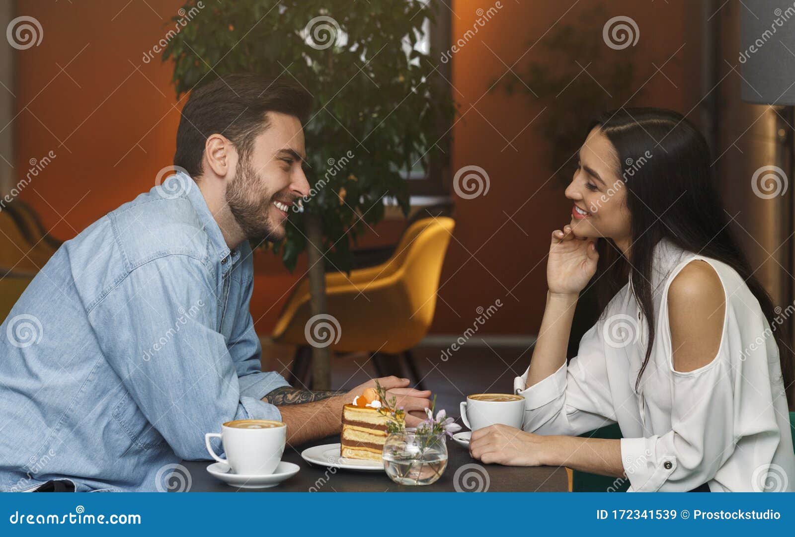 millennial couple in love talking sitting in coffee shop