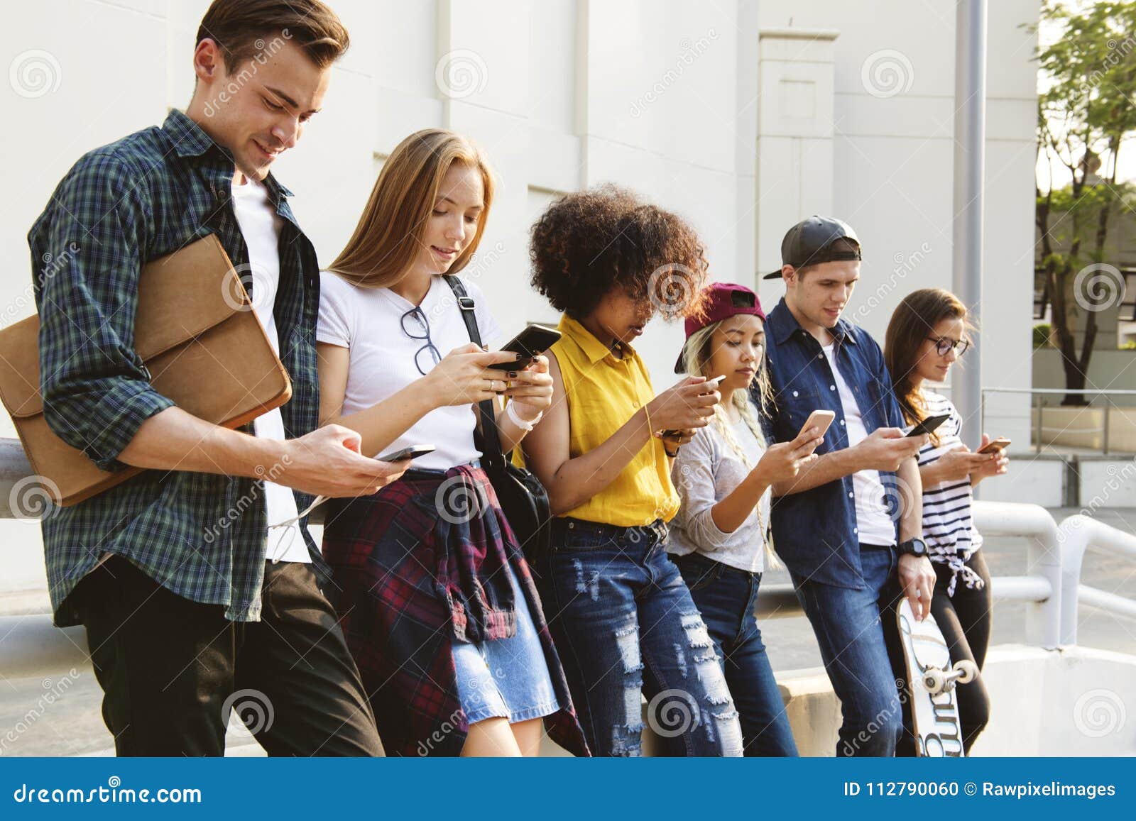millennials using smartphones outdoors together