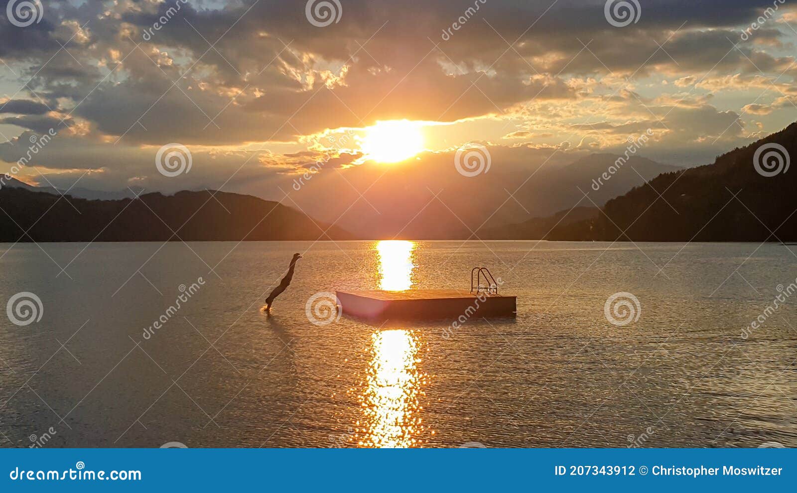 millstaettersee - a man jumping into the millstaettersee lake from a wooden platform during the sunset. the sun is setting