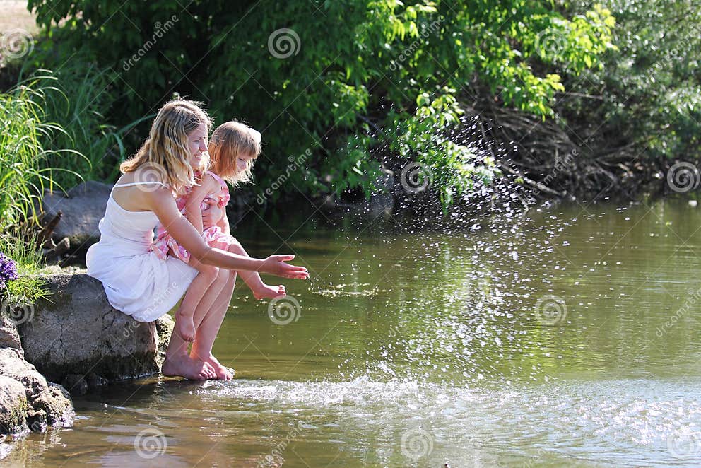 Mime Y Su Pequeña Hija Que Arroja A Chorros El Agua En El Lago Imagen