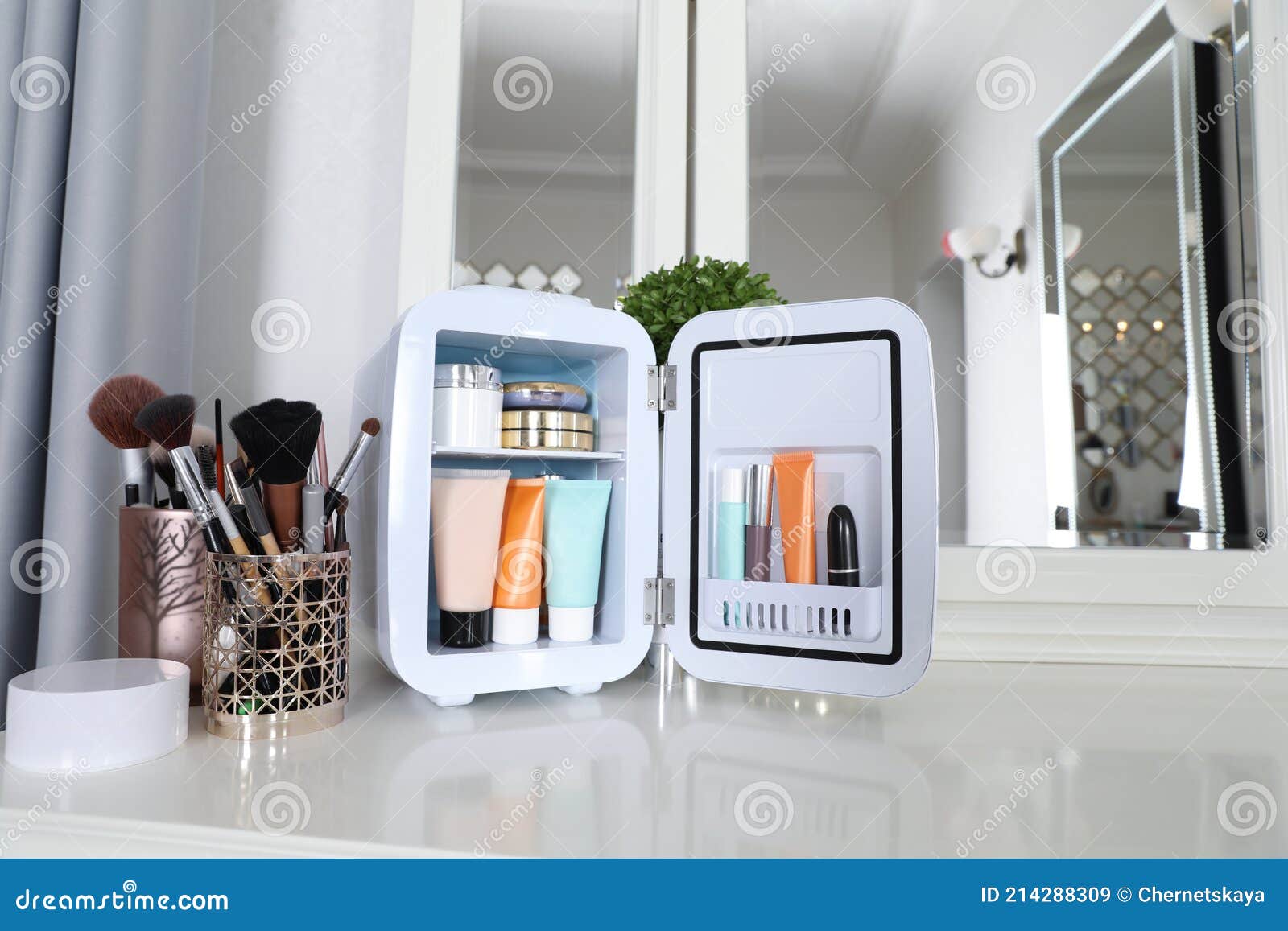 Mini Fridge with Cosmetic Products on White Vanity Table Stock Image