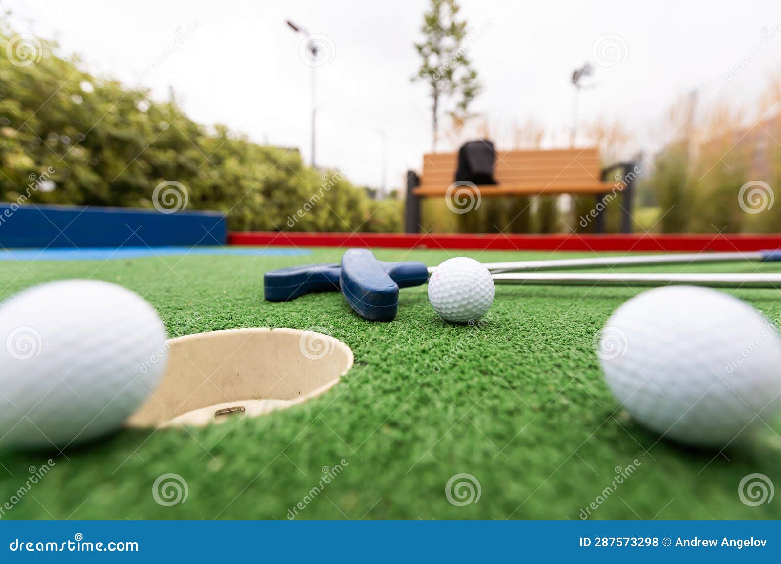 Minigolf Clubs and Balls of Different Colors Laid on Artificial Grass