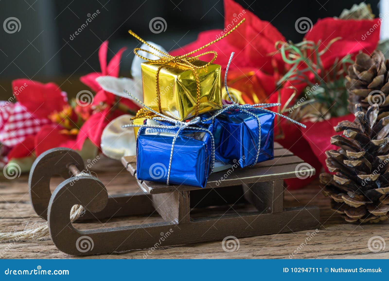 Miniature golden and blue present gift boxes on Santa claus sleigh as christmas eve celebration concept.