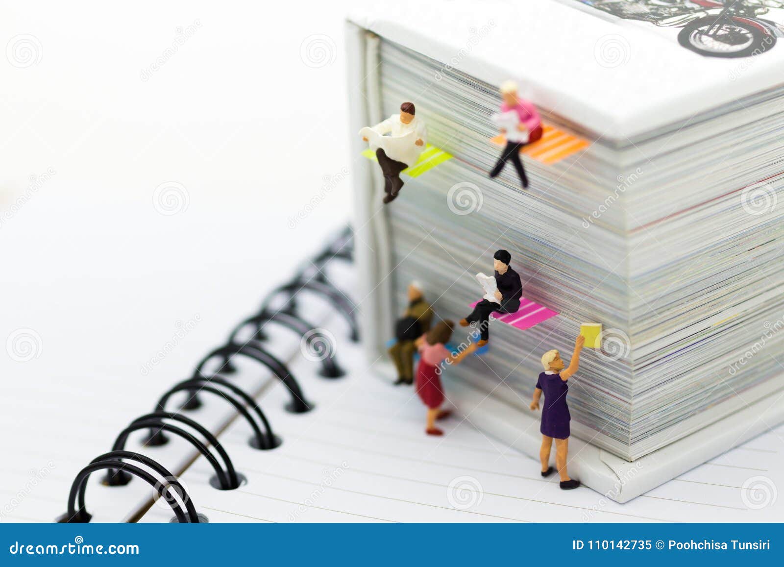 miniature people: businessman reading newspaper on a big book. image use for background education or business concept