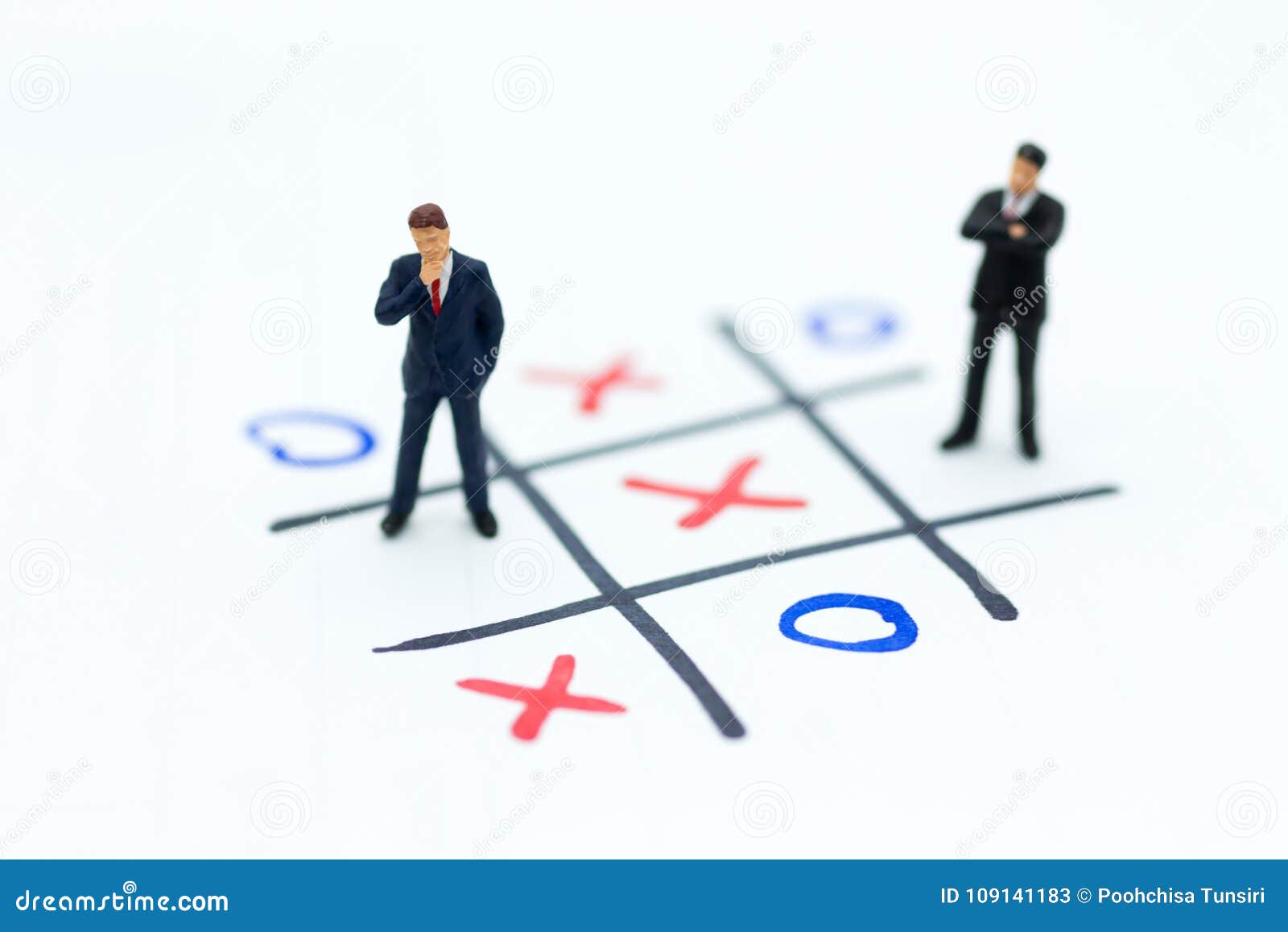 miniature people: businessmen stand on xo game board. image use for business competition concept