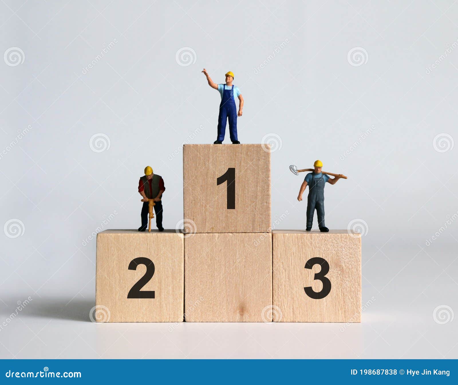 miniature people standing on top of the ranked wooden blocks.