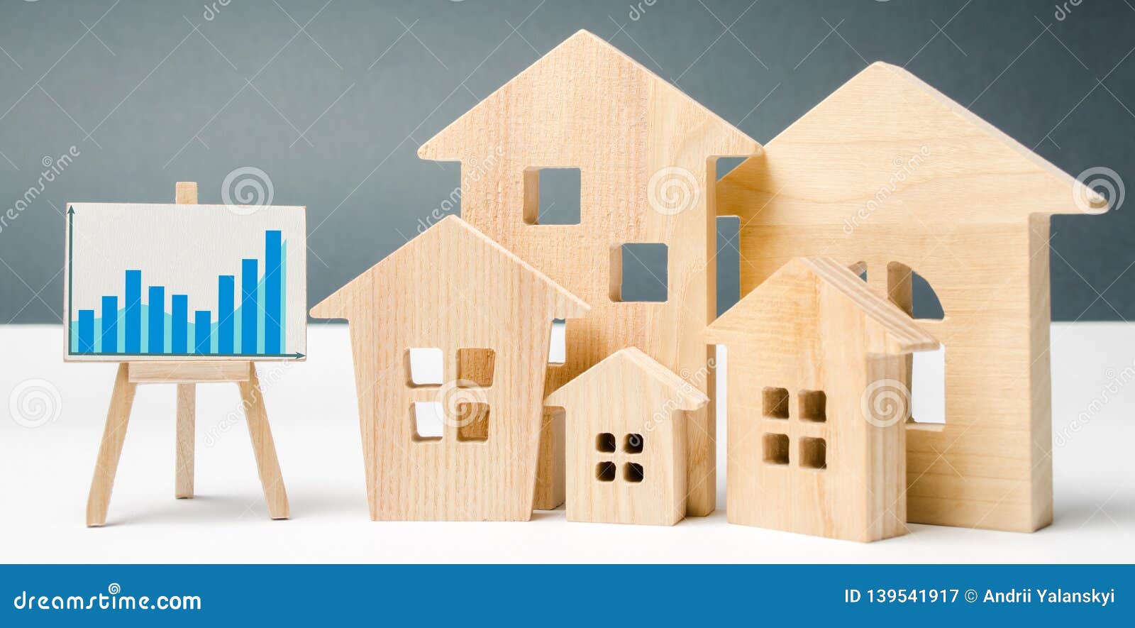 miniature wooden houses and chart. real estate. city. agglomeration and urbanization. real estate market analytics. demand for