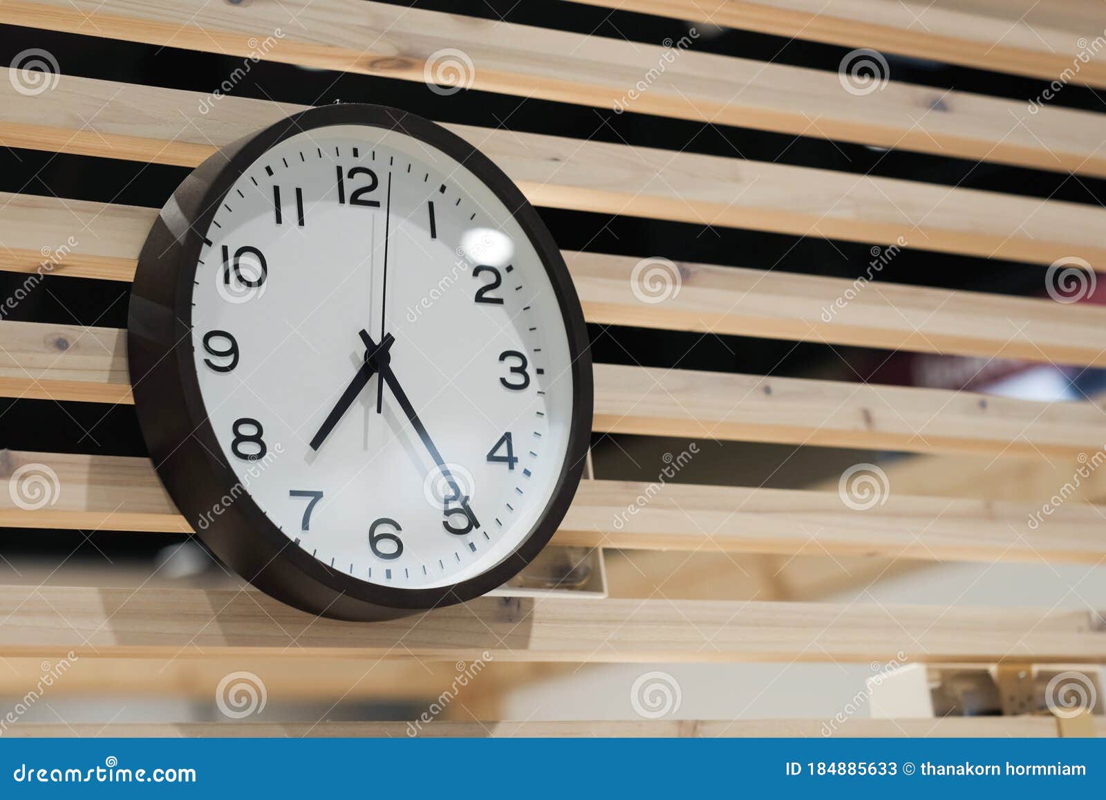 Minimal Style Black and White Clock Hanging on Wood Wall Stock Image