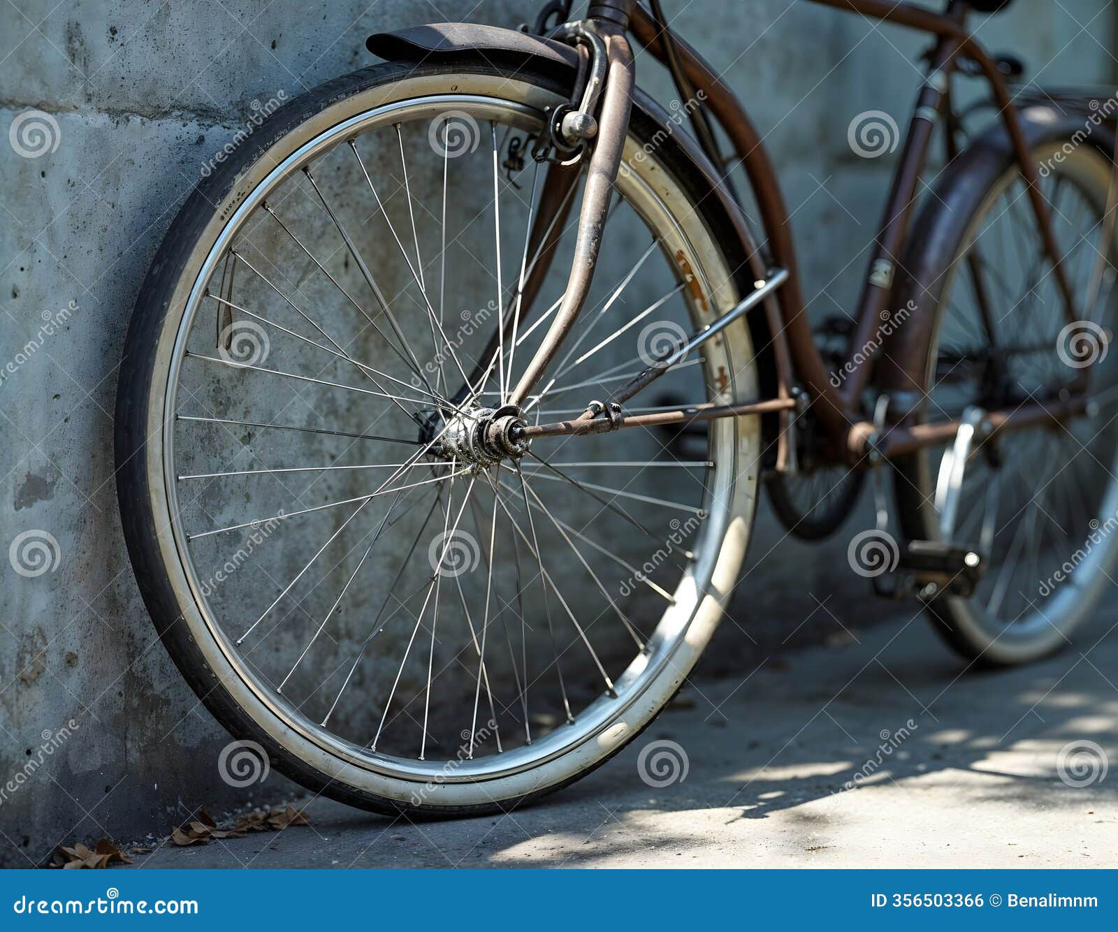 minimalist bicycle wheel  against textured concrete wall