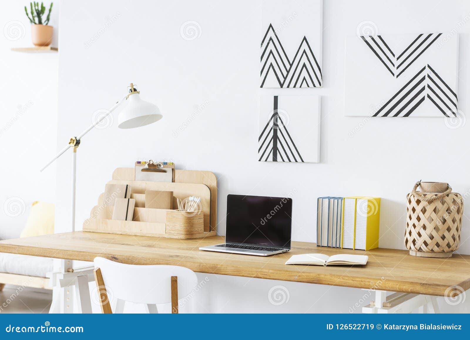 Minimalist Paintings on a White Wall Above a Wooden Desk with a ...