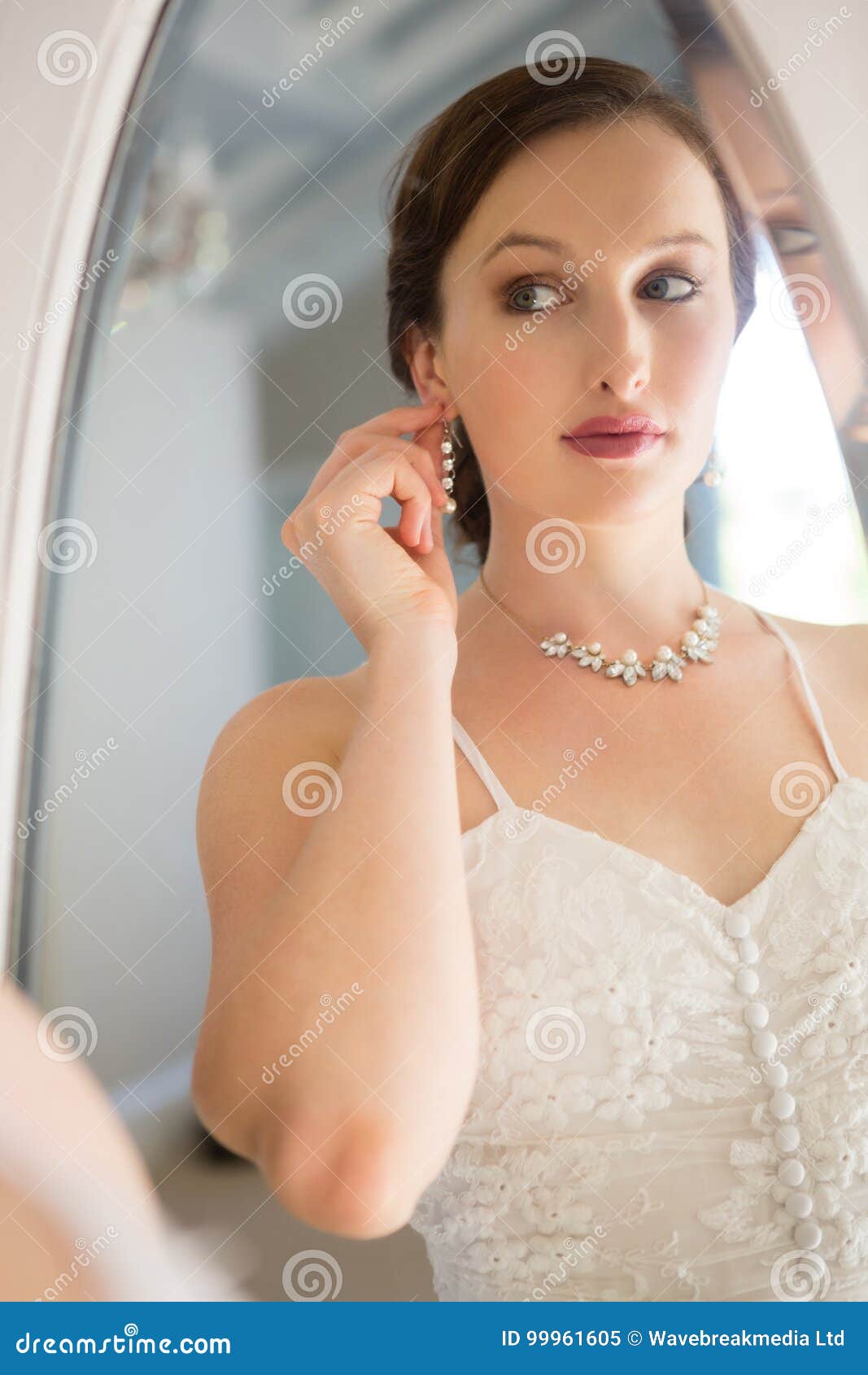 Mirror with Reflection of Beautiful Bride Wearing Earring Stock Image