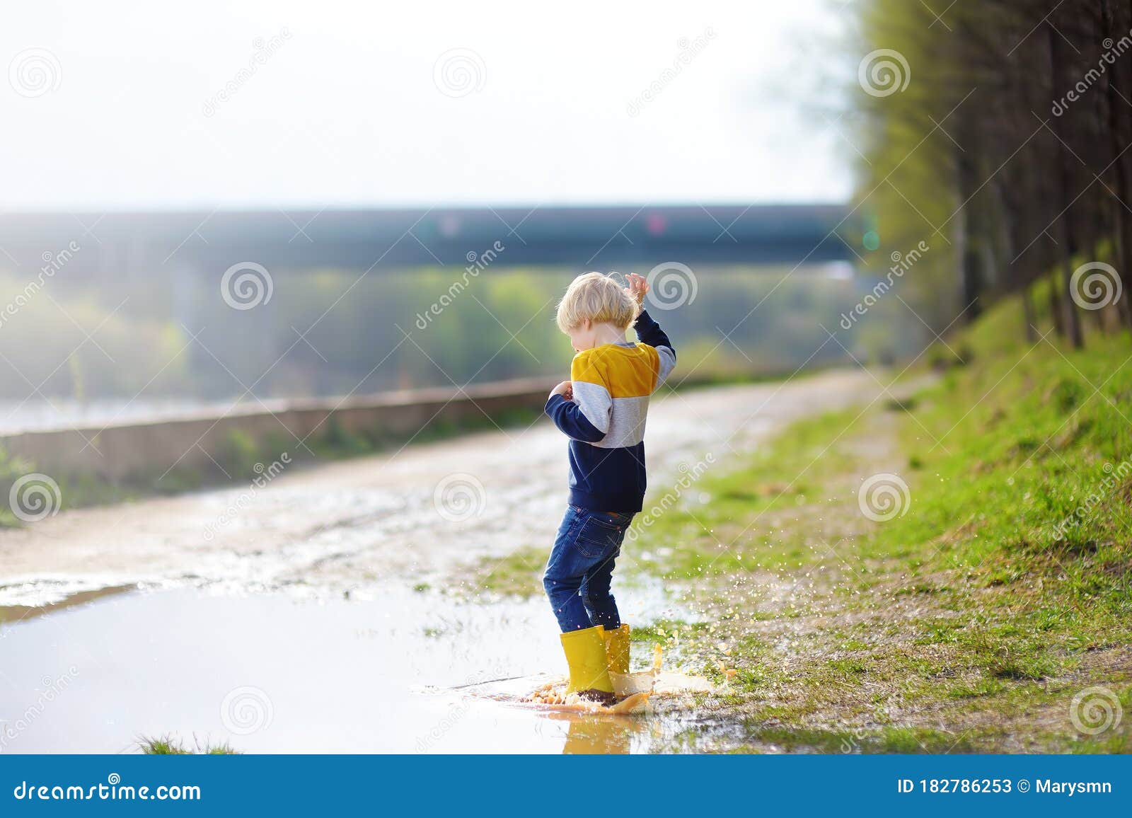 Mischievous Preschooler Child Wearing Yellow Rain Boots Jumping in ...