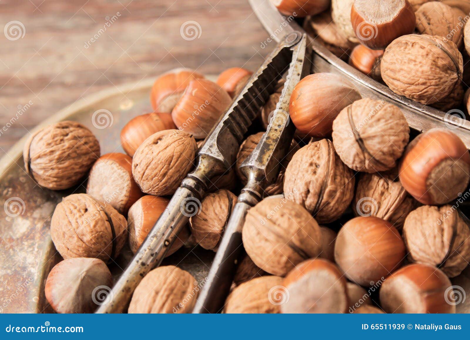 Mischung von Nüssen auf Metallplatten mit Weinlese orehokolom. Mischung von Nüssen auf einer Metallplatte mit orehokolom auf einem hölzernen Hintergrund