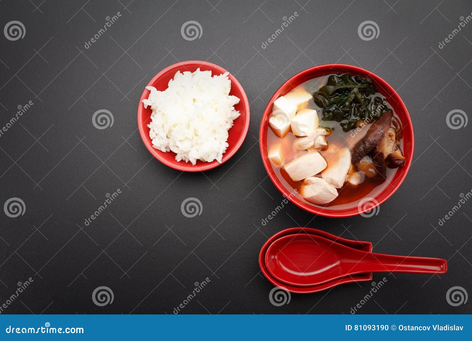 Miso Soup and Rice on a Red Bowl and Spoon on the Table. Stock Photo