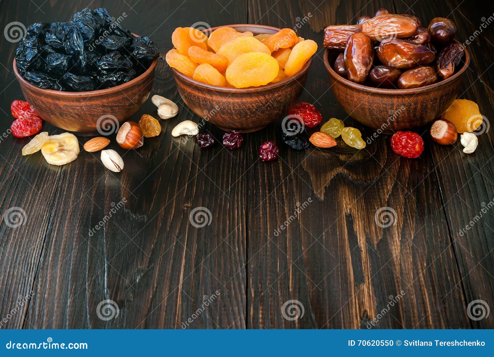 mix of dried fruits and nuts on a dark wood background with copy space. s of judaic holiday tu bishvat.