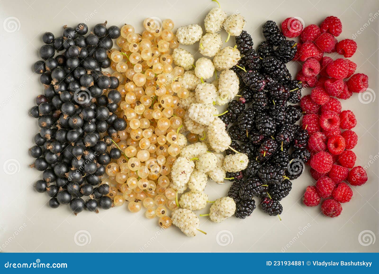 mix of fresh berries in on plate on wooden background. antioxidants, detox diet, organic fruits.
