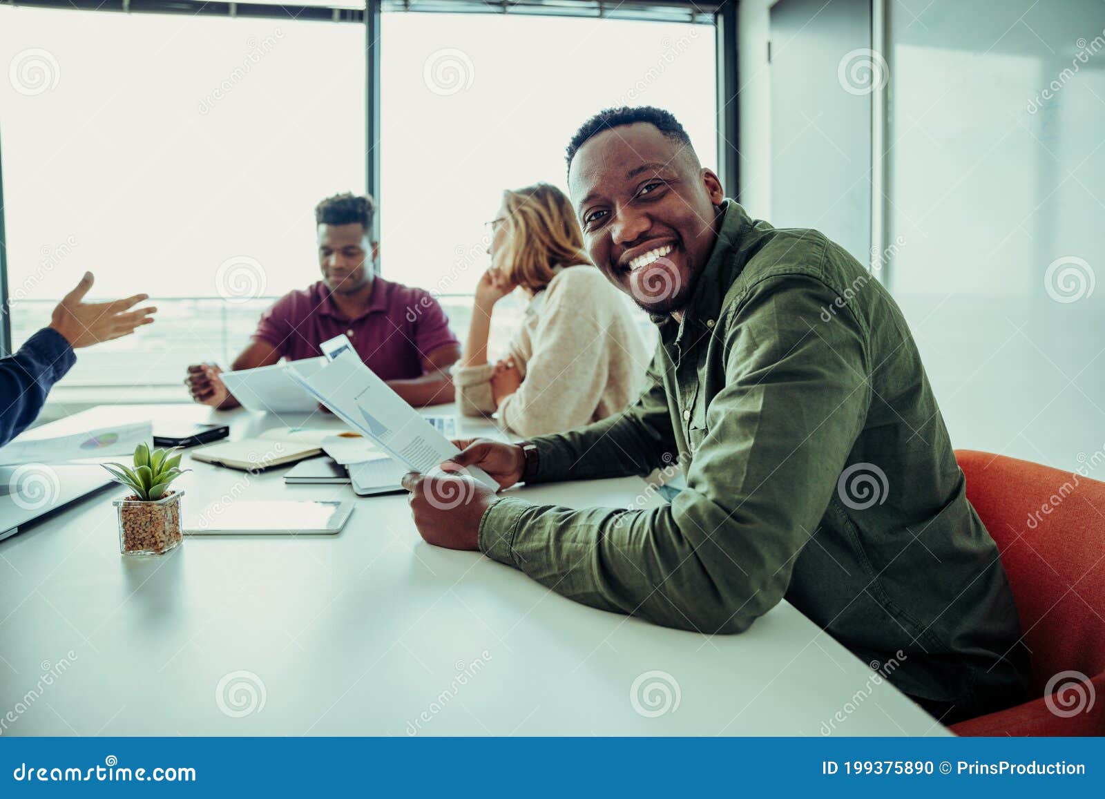 Mixed Race Business Man Smiling Working through Paperwork with 