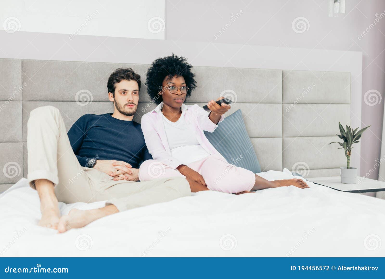 Happy Mixed Race Couple Relax On Couch In Living Room Watch Movie