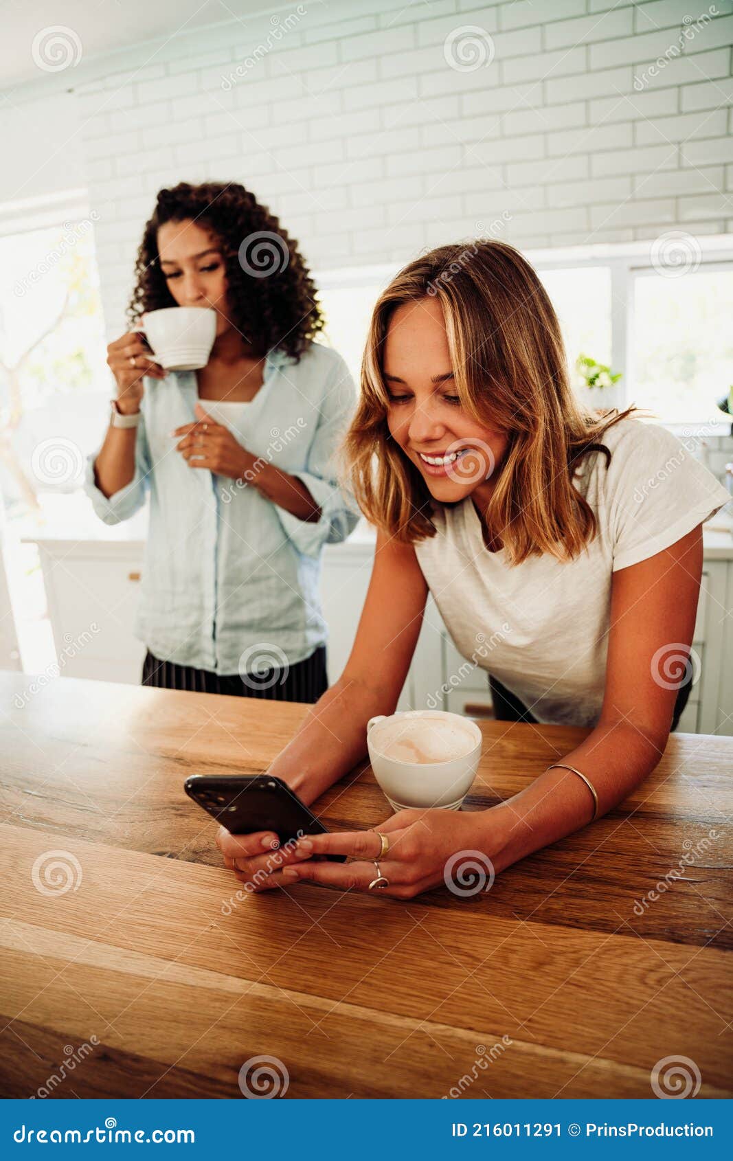 Mixed Race Friends Relaxing in Kitchen Bonding Together Drinking