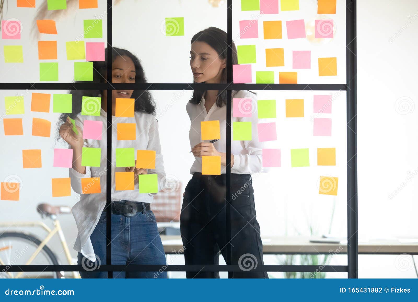 mixed race managers working together near kanban board.