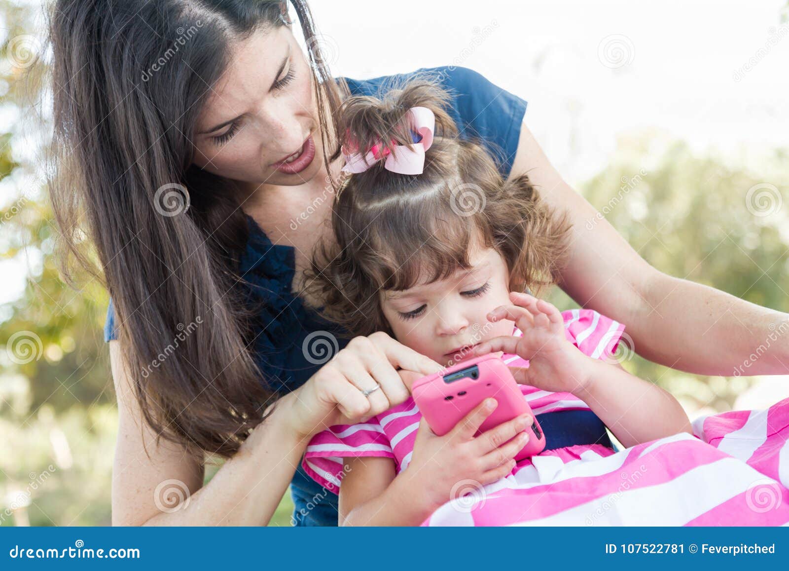 Mixed Race Mother Helps Cute Baby Daughter With Smart Phone Stock