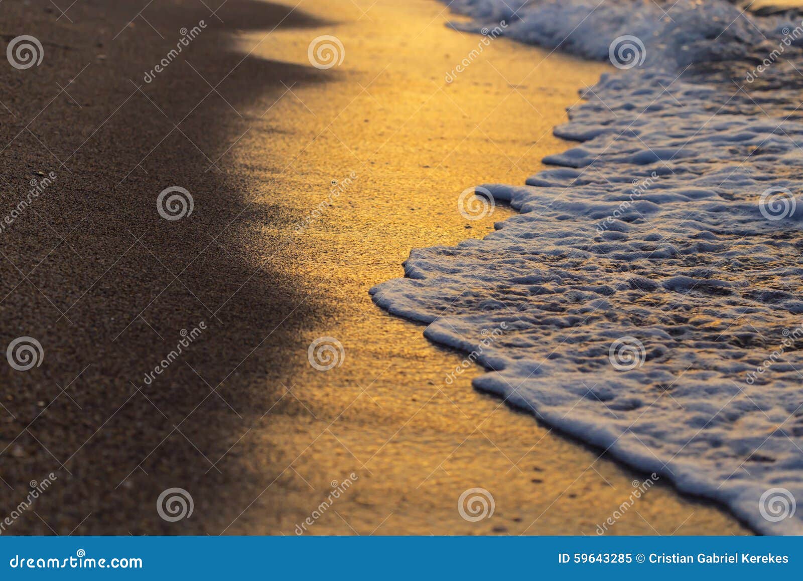 Miękkiej części fala na plaży przy zmierzchem tworzy złotych kolory. Macha na plaży przy zmierzchem tworzy złotych kolory