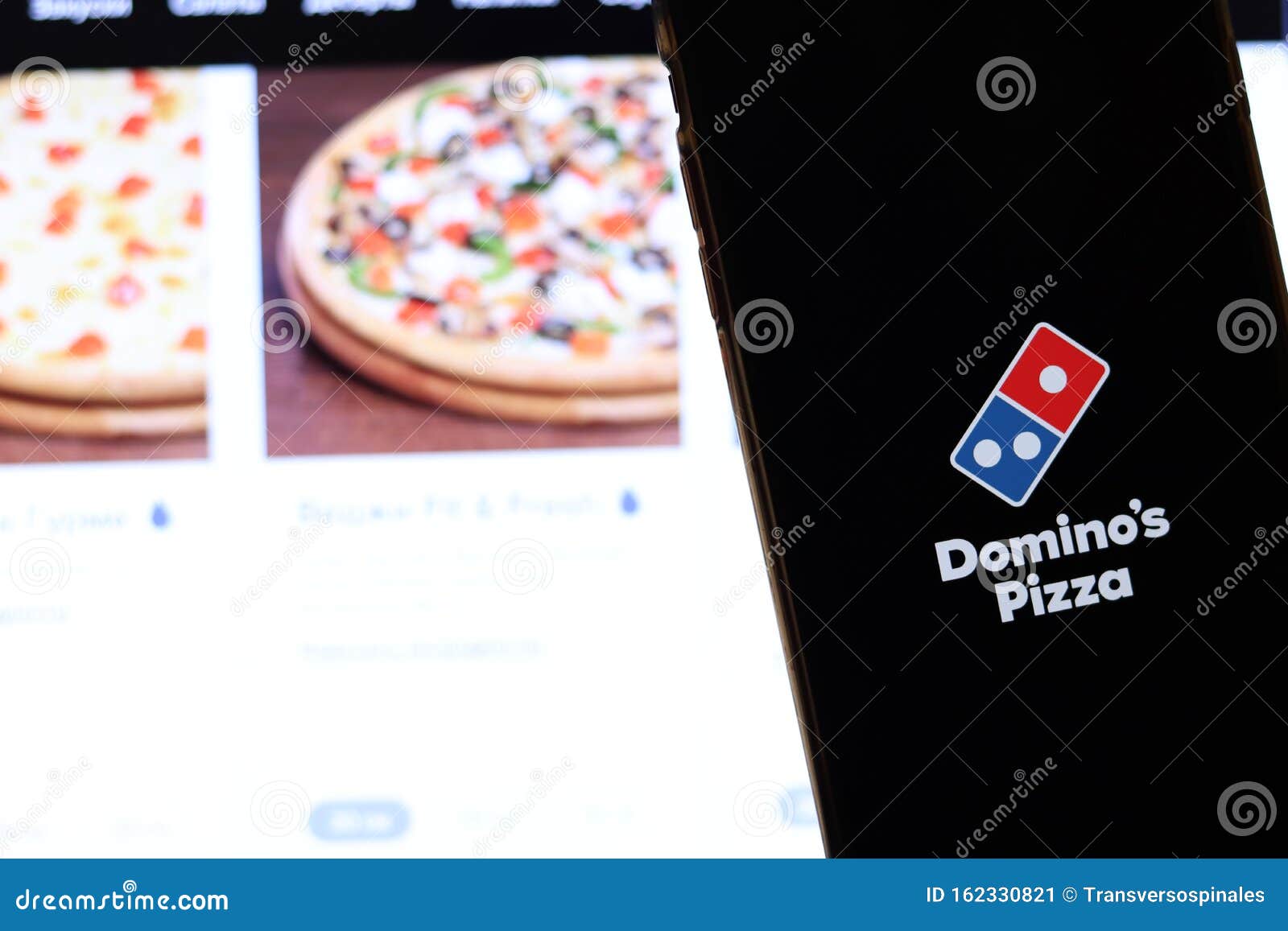 Mooie vrouw Gepland Ideaal Mobiele Telefoon Met Domino's Pizza Logo Op Scherm Dicht Bij De Website Op  Laptop Blurred Background Met Dominos Pizza Redactionele Foto - Image of  toepassing, domino: 162330821