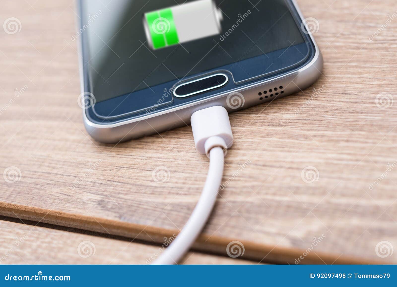 mobile phone and battery charger cable on office desk