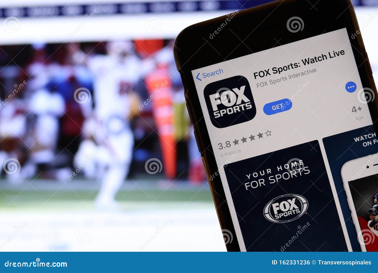 Mobile Phone with Fox Sports Watch Live Logo on Screen Close Up with Website on Laptop