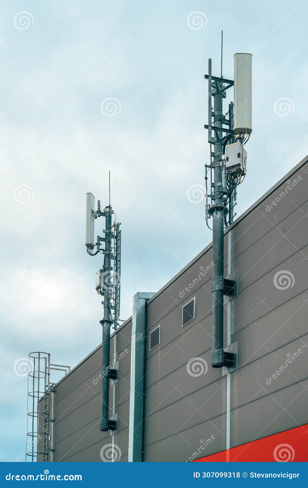 mobile telephony base station and signal repeater antenna on industrial building