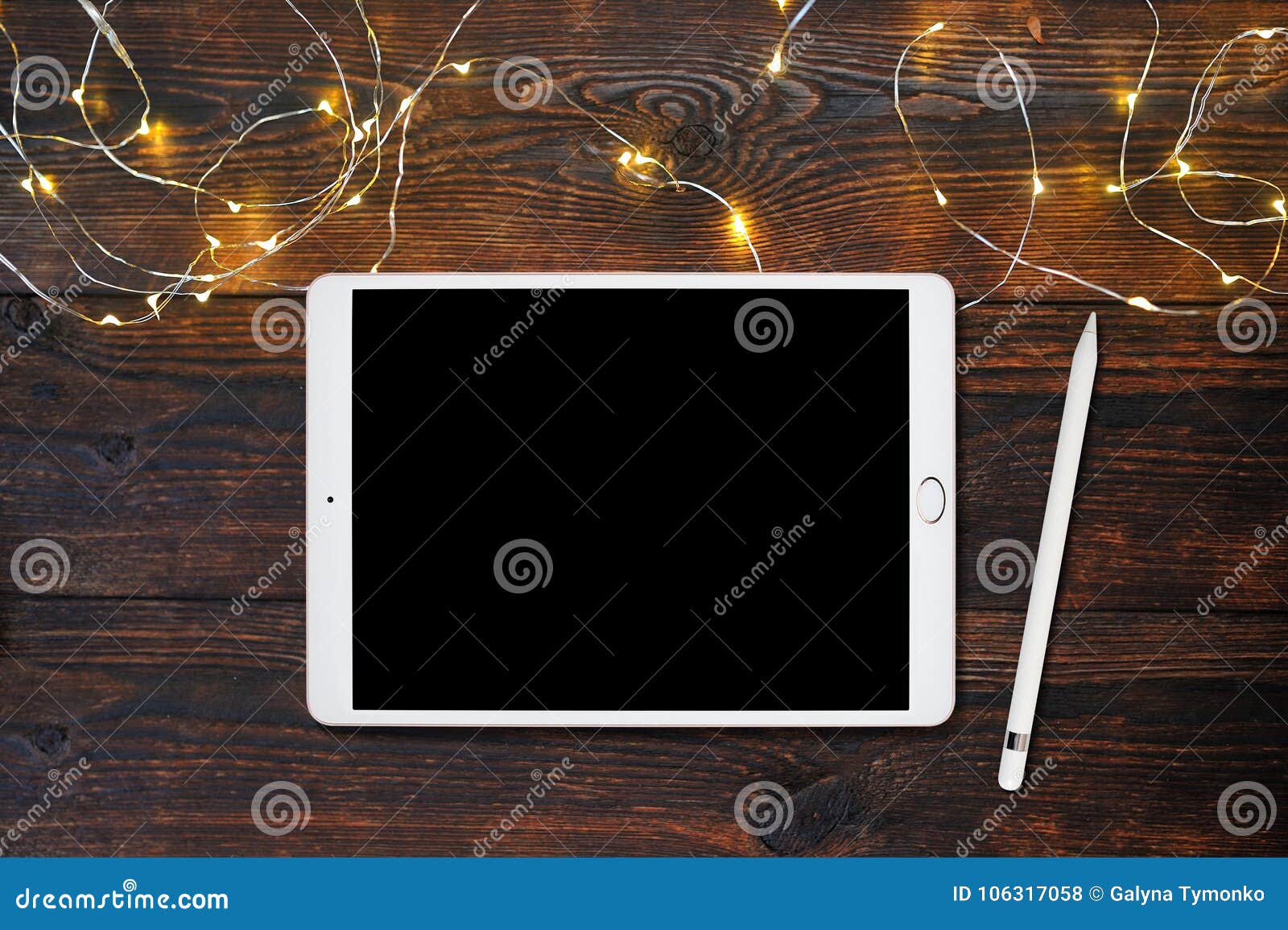 mockup tablet computer and pencil on old wooden table with garland, flatlay on a white wooden background, with place for your text