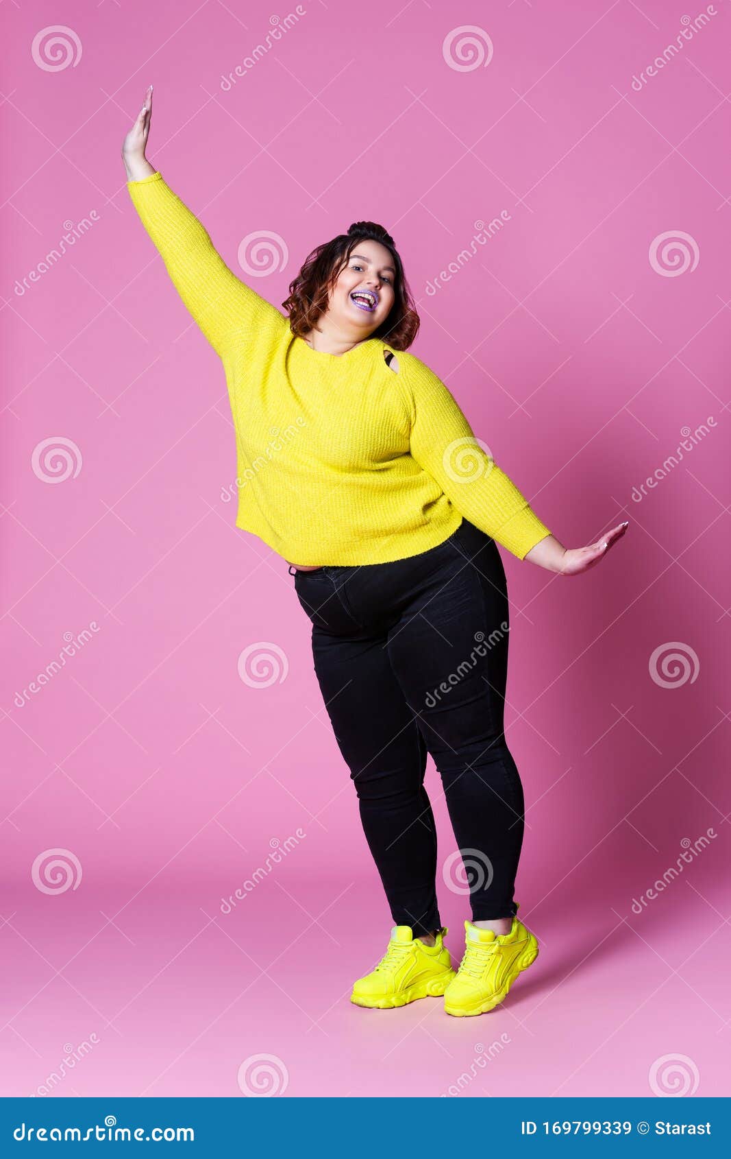 https://thumbs.dreamstime.com/z/mod%C3%A8le-plus-gaie-de-taille-dans-la-grosse-femme-v%C3%AAtements-sport-en-jeans-noir-et-pull-jaune-sur-le-fond-rose-portrait-complet-du-169799339.jpg