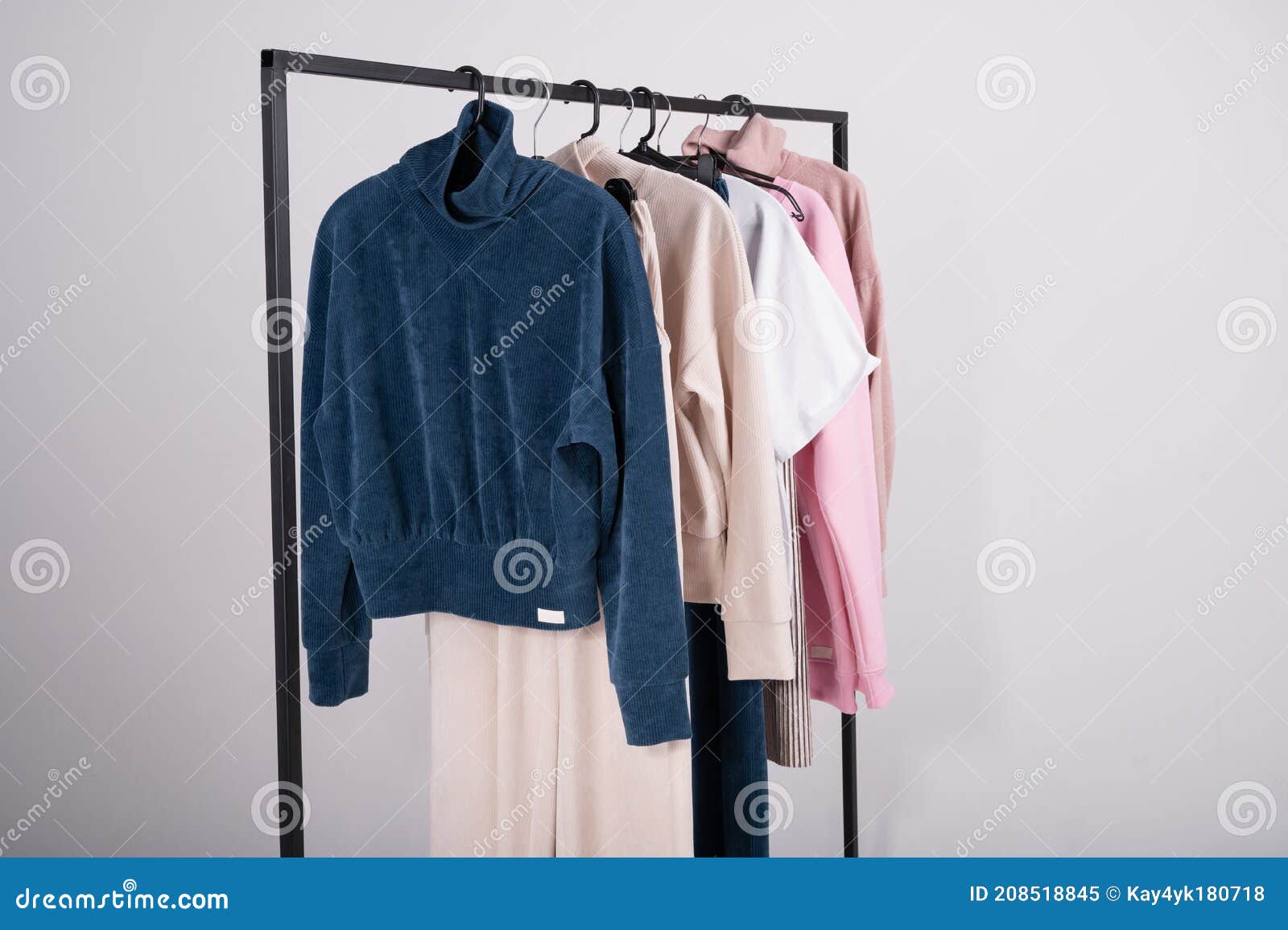 Moda Primaveral Ropa Casual En Un Rack. Elegantes Camisetas Femeninas Con Pantalones De Caramelo El Colgador De Fon Imagen de archivo - de nupcial, tela: