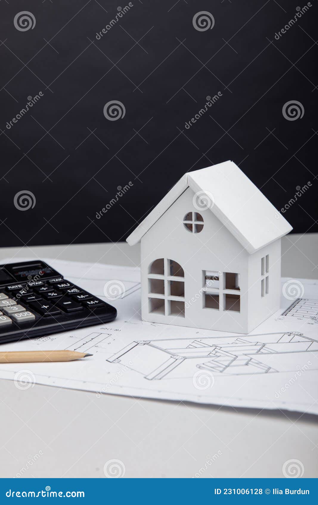 Model of House and Calculator on Architectural Plan. House Building