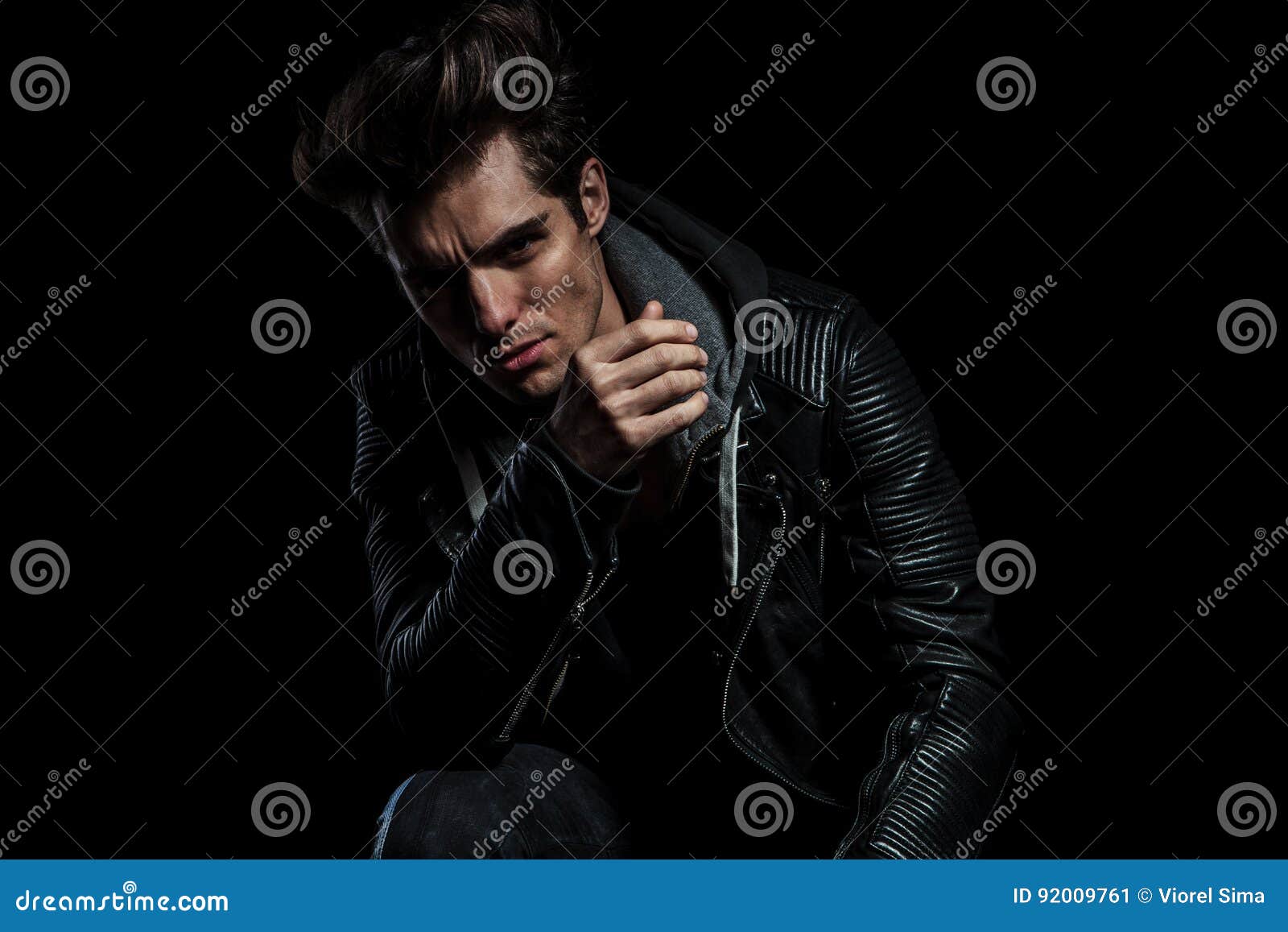 Model in Leather Jacket Resting Elbow on Knee while Seated Stock Image ...