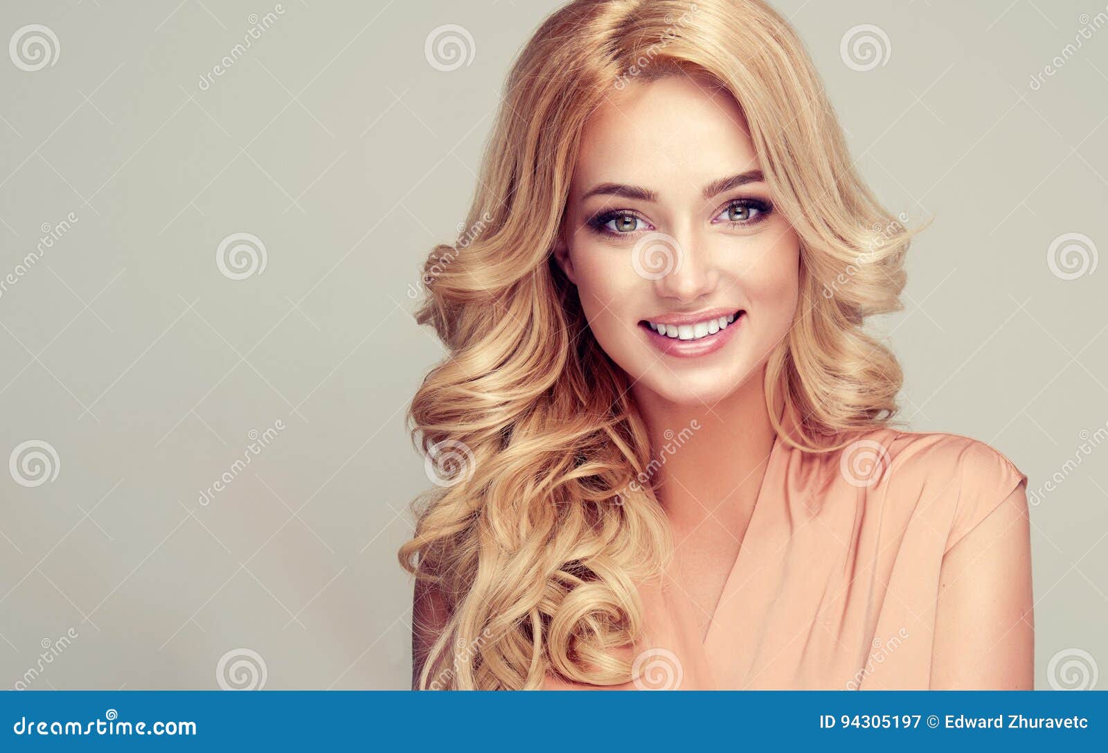 model with long, dense, hairstyle and white toothy smile.