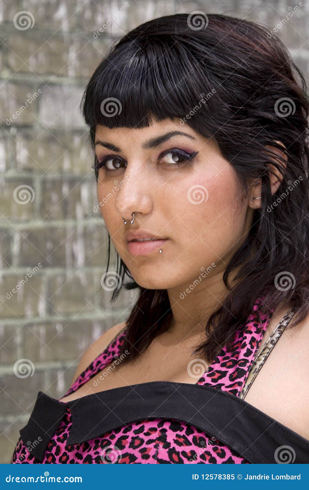 Model with piercings. Portrait of attractive young female with piercings in nose and lips