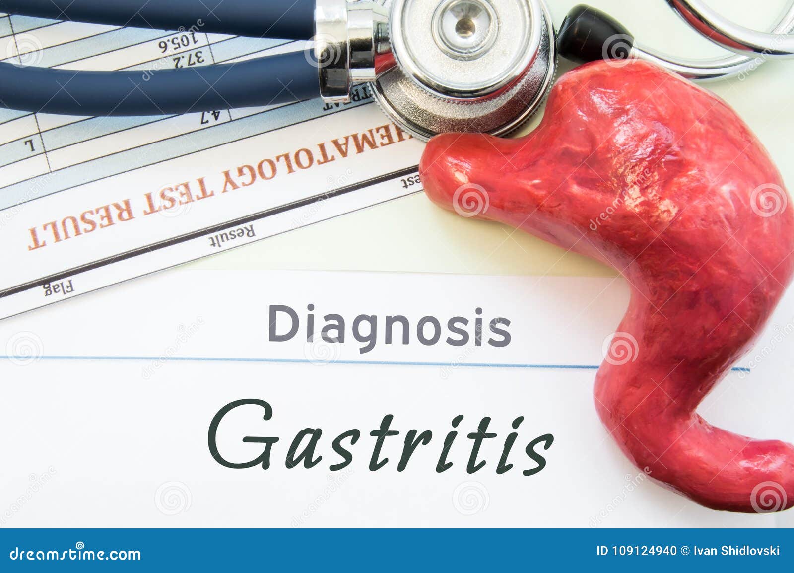 model of stomach, blood test and stethoscope lying next to written title on paper diagnosis gastritis. concept photo of causes, di